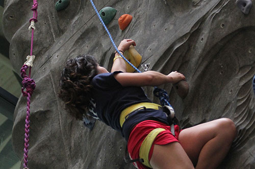 A student climbs the rock wall at St. Mary's AA&CC athletic facility