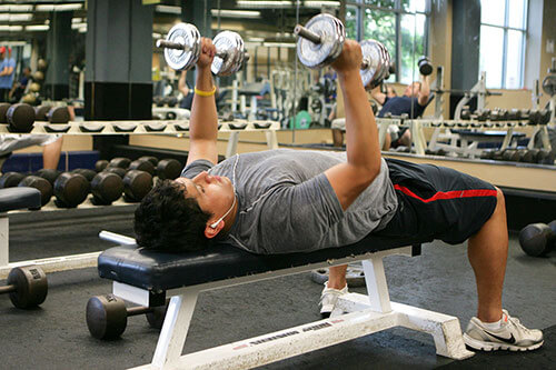 A student lifts weights inside the AA&CC athletic facility