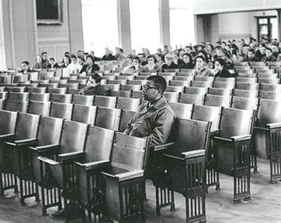 Young Louis Cousins sit alone in auditorium