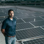 Supratim Srinivasan (B.S. '11) stands among solar panels.