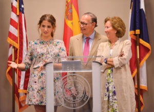 Cayetana Roca de Togores (from left), granddaughter to the Duque de Béjar; Duque de Béjar Pedro Roca de Togores; Duquesa Marta Garcia Perez, stand at a podium.